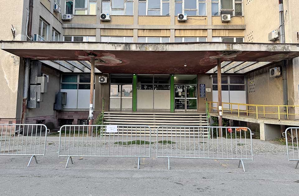 Glavni ulaz u staru Specijalističku polikliniku ograđen metalnim ogradama – stoji i natpis